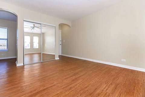 A room with wooden floors and a large mirror on the wall.