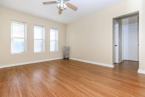 A room with wooden floors and a ceiling fan.