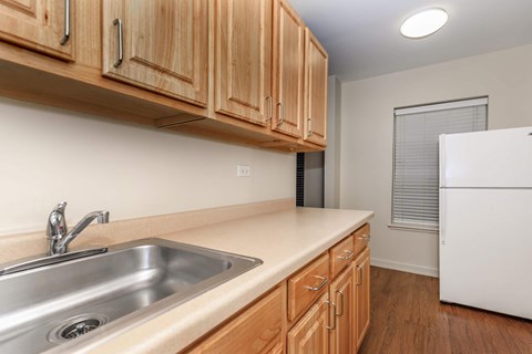 A kitchen with wooden cabinets and a white refrigerator.