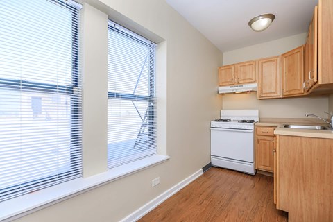 A kitchen with wooden cabinets and a white dishwasher.