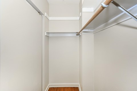 A white hallway with a wooden floor and white walls.