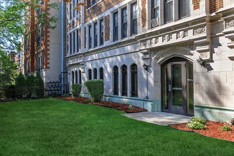 A large building with a green lawn in front.