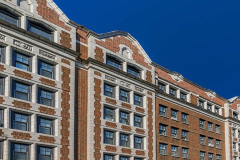 A tall building with many windows and a brick facade.