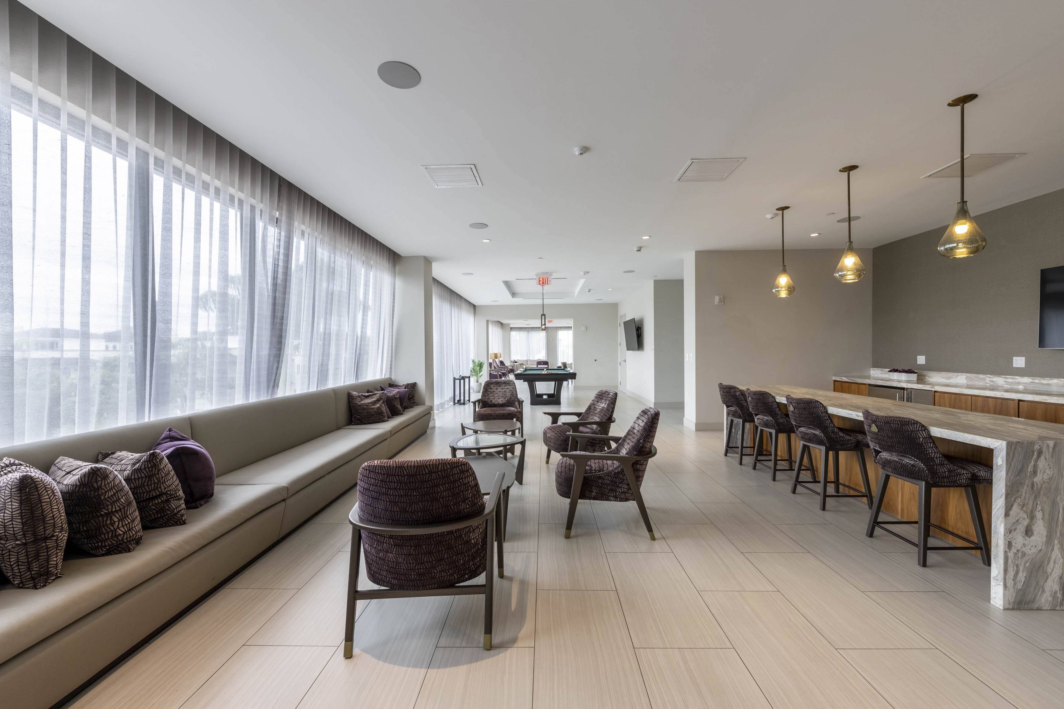 A modern living room with a long couch and a bar area.