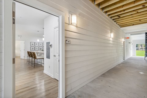 A hallway with a white door leading to a dining area.