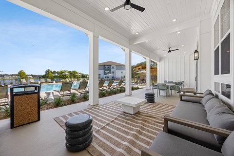 A patio with a striped rug and a black trash can.