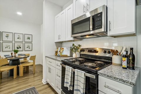 A modern kitchen with a stove top oven and microwave above it.