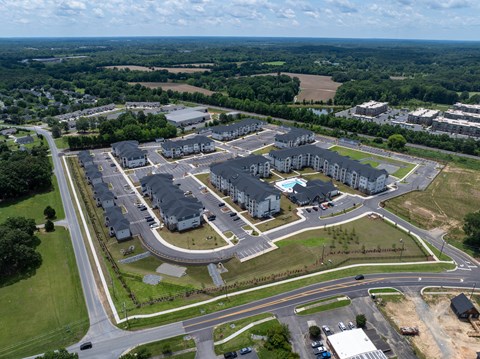 A bird's eye view of a residential complex with multiple buildings and roads.
