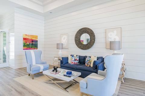 A living room with a blue couch and a white chair.