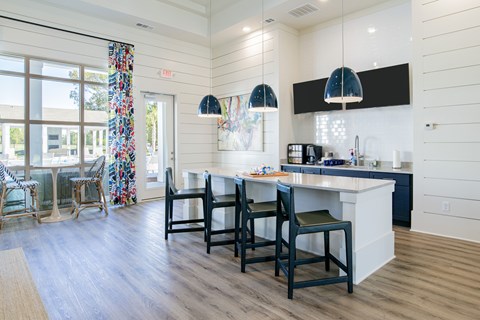 A kitchen with a white counter and black chairs.