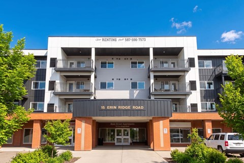 A multi-story building with a sign that reads "15 Erin Ridge Road" in front of it.