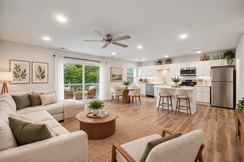 A well-lit, modern living room with a kitchen in the background.