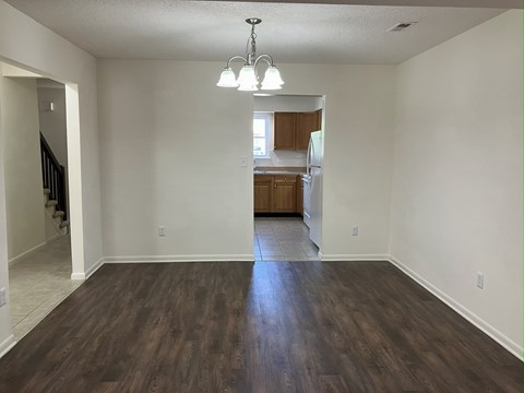 A room with wooden floors and a chandelier.