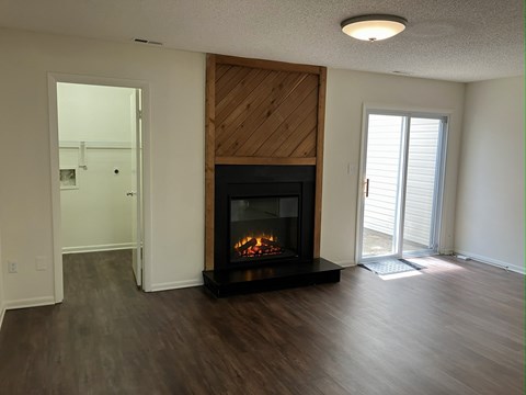 A modern living room with a fireplace and sliding glass doors.
