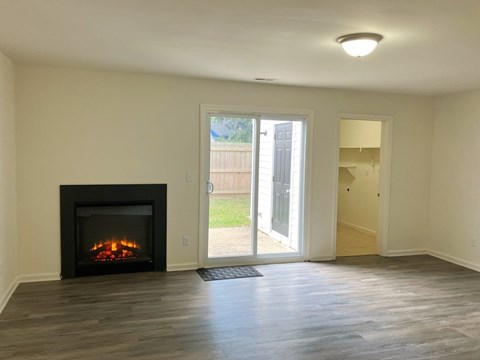A room with a fireplace and sliding glass doors.