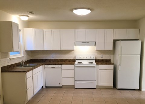A kitchen with white appliances and cabinets.