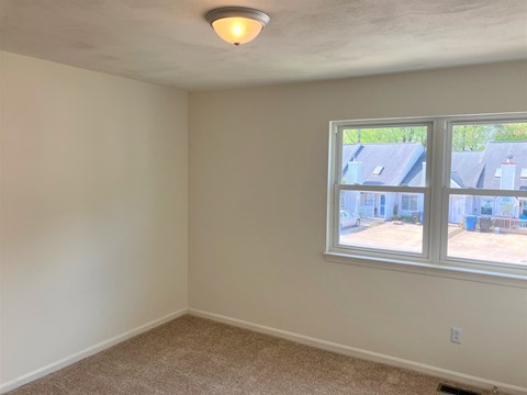 A room with a window and a ceiling light.