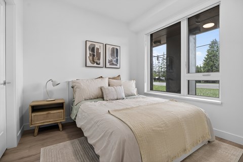 A bedroom with a large bed and two pictures on the wall.
