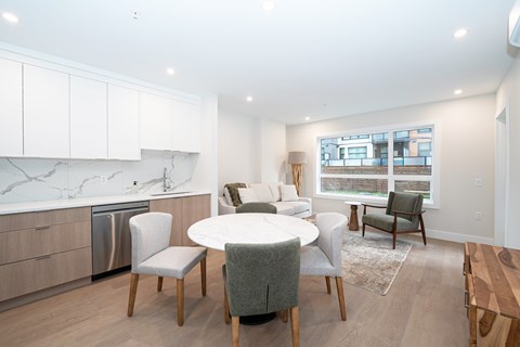 A modern kitchen with a dining table and chairs.