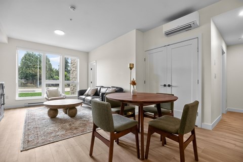 A dining room with a table and chairs.