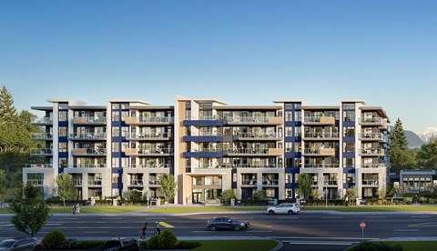 A large apartment complex with a parking lot in front.