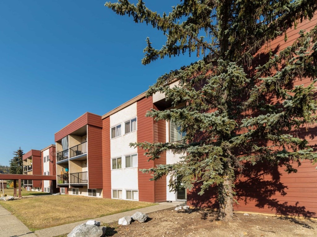 A red and white building with a tree in front.