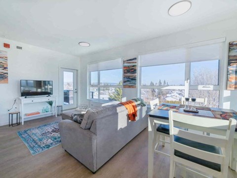 A living room with a grey couch and a white chair.