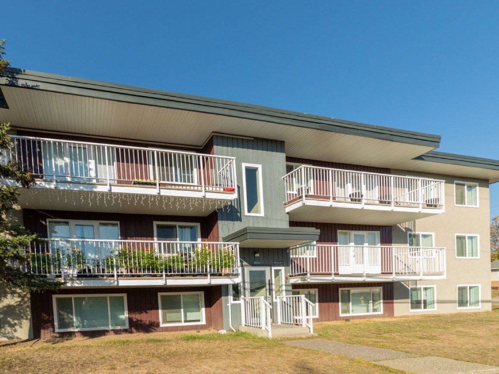 Apartment building with balconies and a clear blue sky.