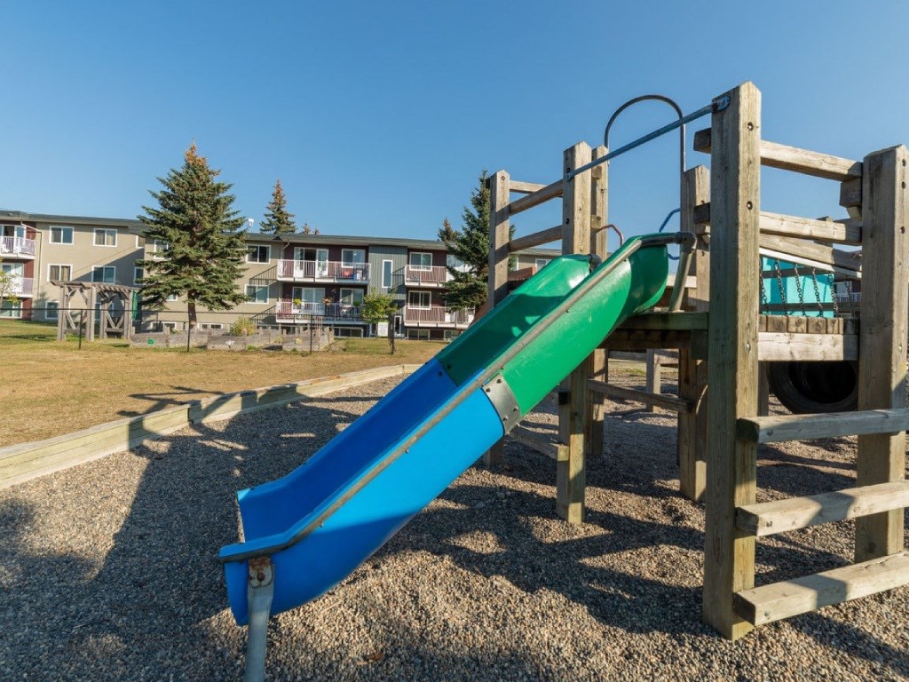A blue and green slide in a playground.