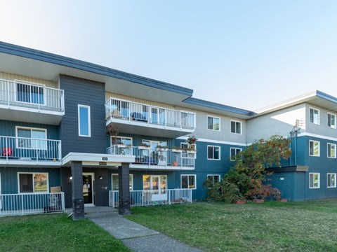 A building with a blue and white exterior and a balcony.