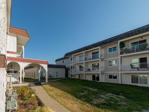 A building with a red roof and a white building with a balcony.