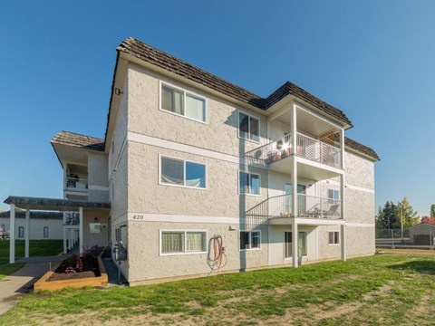 A modern two-story apartment building with a balcony on the second floor.