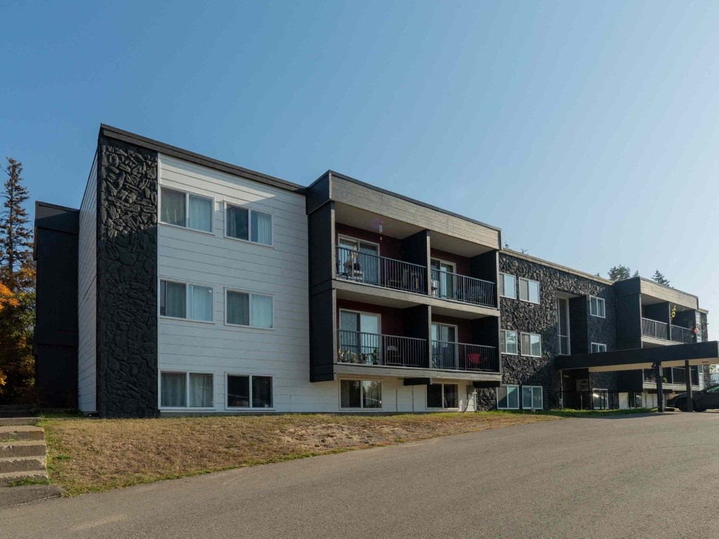 A modern apartment building with balconies and a clear sky.