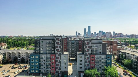 A cityscape with apartment buildings in the foreground and a city skyline in the background.