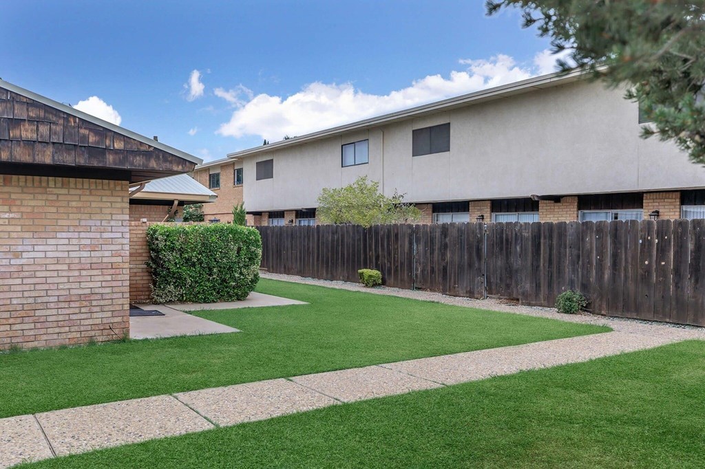 A house with a green lawn and a wooden fence.