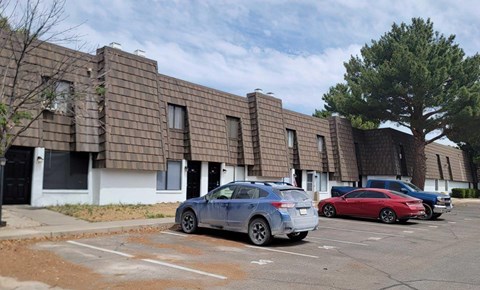 A parking lot with cars and a building in the background.