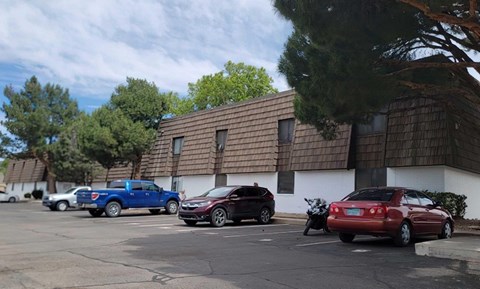 A parking lot with cars and a building in the background.