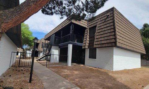 A modern house with a white exterior and a brown roof.