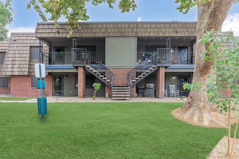 A building with a green lawn in front.