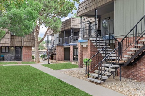 A building with a staircase and a tree in front.