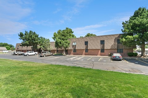 A parking lot with cars and a building in the background.