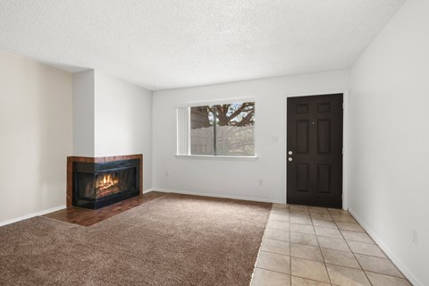 A room with a fireplace and a brown carpet.