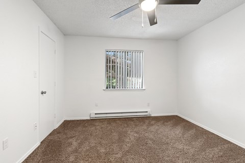 A room with a window and a ceiling fan.