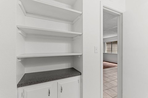 Empty white shelves in a kitchen.