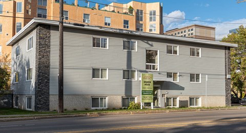 A building with a sign that says "For Sale" in front of it.
