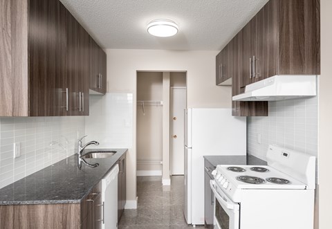 A kitchen with a white stove and a black countertop.