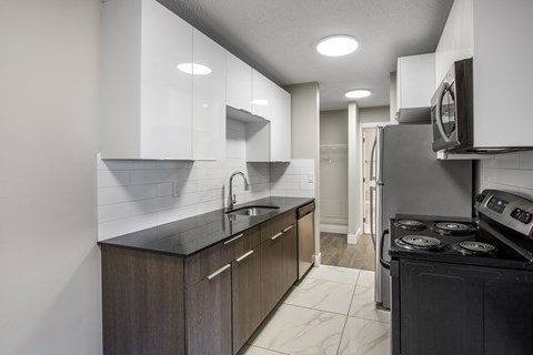 A modern kitchen with dark wood cabinets and a black stove top oven.
