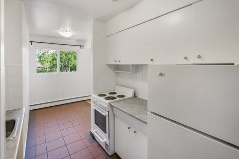 A kitchen with white cabinets and a stove top oven.