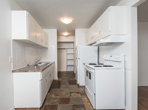 A kitchen with white appliances and cabinets.