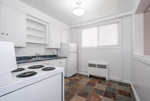 A kitchen with white appliances and cabinets.